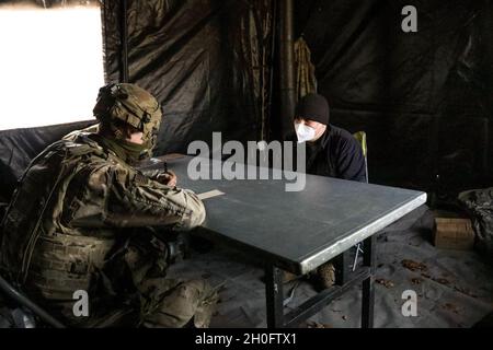 Un soldat américain affecté à la 64e Compagnie de police militaire, 91e Bataillon de génie de brigade interroge un suspect simulé pendant la résolution combinée XV à la zone d'entraînement de Hohenfels, Hohenfels, Allemagne, le 27 février 2021.Combined Resolve XV est un exercice multinational dirigé par le département de l'Armée de terre conçu pour construire l'équipe de combat de la 1re Brigade blindée, la préparation de la 1re Division de Cavalry et améliorer l'interopérabilité avec les forces alliées pour combattre et gagner contre tout adversaire. Banque D'Images