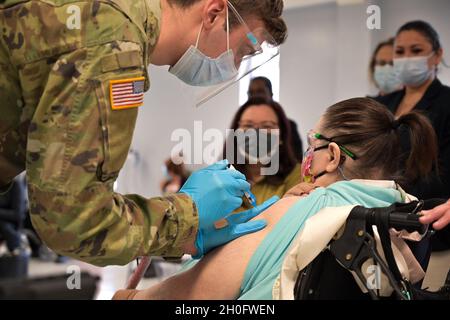 Le sénateur Tammy Duckworth observe le medic de combat de l'armée américaine administrer le vaccin COVID-19 à un patient du bâtiment Athletics du Triton College de des Plaines, Illinois, le 27 février 2021.Duckworth a visité le centre avant une conférence de presse sur les plans de vaccination dans le comté de Cook, en Illinois. Banque D'Images