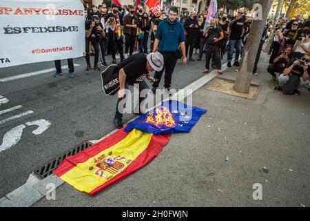 Barcelone, Catalogne, Espagne.12 octobre 2021.Un manifestant est vu mettre le feu sur le drapeau espagnol et le drapeau de l'Union européenne.quelque 400 personnes de groupes antifascistes ont appelé à une manifestation contre les événements du 12 octobre, la Journée hispanique à Barcelone.Les manifestants ont pris la direction de certains de ces actes, mais la police les a empêchés en toutes occasions.(Image de crédit : © Thiago Prudencio/DAX via ZUMA Press Wire) Banque D'Images