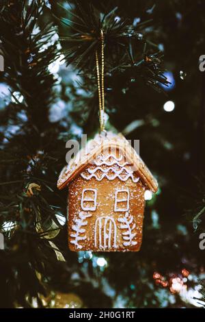 Maison en pain d'épice accrochée à l'arbre de Noël.Décoration de fête du nouvel an.Atmosphère magique de Noël Banque D'Images