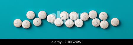 pilules blanches sur fond bleu. bannière blanche de suppléments alimentaires Banque D'Images