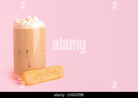 Verre de délicieux Tiramisu Latte sur fond rose Banque D'Images