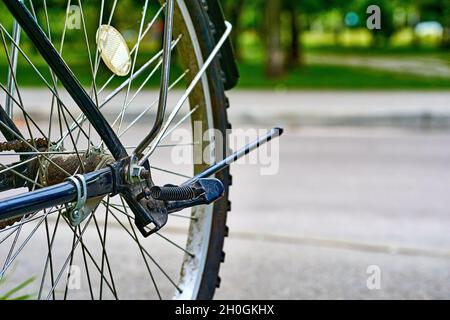 Roue arrière de vélo avec freins sur fond de route et de stationnement Banque D'Images