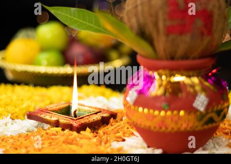 Flammes droites vives éclairant de Clay Diya Deep Dia placé sur Marigold Flower Rangoli avec Kalash sur le côté.Navratri Pooja, Dussehra Puja, N Banque D'Images