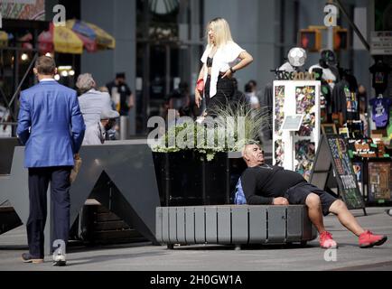 New York, États-Unis.12 octobre 2021. Des piétons marchent à côté d'un homme qui dort à Times Square à New York le mardi 12 octobre 2021.Photo de John Angelillo/UPI crédit: UPI/Alay Live News Banque D'Images