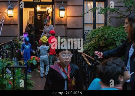 Une femme qui donne des bonbons à trick ou des Treators pour Halloween à New York. Banque D'Images
