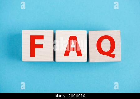 Les lettres FAQ sont debout sur des cubes en bois, fond bleu, Foire aux questions Banque D'Images