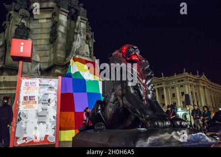 Barcelone, Espagne.12 octobre 2021.La statue du lion du monument de Christophe Colomb est visible sous la peinture rouge devant un drapeau de Wiphala.divers groupes anticolonialistes ont appelé une manifestation qui a quitté les Ramblas de Barcelone jusqu'à la statue de Christophe Colomb, avec les slogans « ils ne nous conquéront pas » et « rien à célébrer ».Les groupes ont protesté contre la célébration du 12 octobre, jour hispanique.Diverses présentations culturelles et représentations de peuples autochtones de pays d'Amérique latine et d'Afrique ont été réalisées.Crédit : SOPA Images Limited/Alamy Live News Banque D'Images