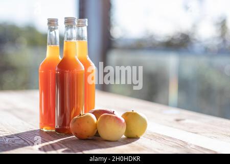 Jus de pomme naturellement nuageux, fait maison dans une bouteille de jus avec des pommes à la lumière de l'automne Banque D'Images