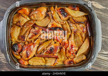 Cuisses de poulet au miel, aux raisins secs, aux pommes caramélisées et aux poires cuites au four Banque D'Images