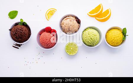 Divers de crème glacée saveur de bleuets ,balle ,lime ,pistache ,amandes chocolat et vanille, orange sur fond de bois blanc . L'été et Swee Banque D'Images