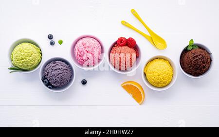 Divers de crème glacée saveur de bleuets ,balle ,lime ,pistache ,amandes chocolat et vanille, orange sur fond de bois blanc . L'été et Swee Banque D'Images