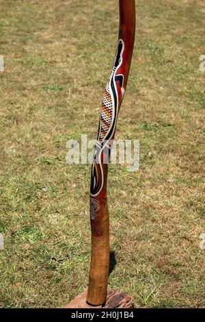 Eungella, Queensland, Australie - octobre 2021 : un didgeridoo aborigène peint à la main, debout sur fond herbacé Banque D'Images