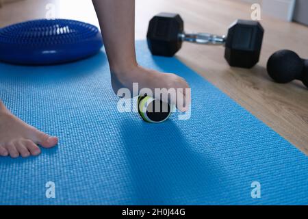 Le pied de l'enfant repose sur une petite balle de gymnastique pour masser les pieds de près Banque D'Images