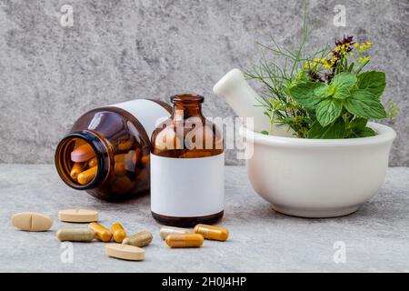 Parallèles en santé des herbes fraîches, de romarin thym-citron ,le fenouil menthe poivrée, basilic, fines herbes et fleurs avec capsule mortier sur fond de pierre. Banque D'Images