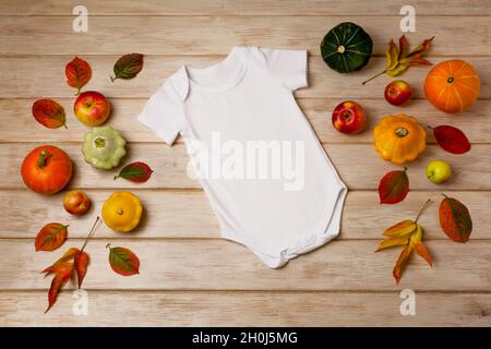 Mackup en coton blanc à manches courtes avec feuilles d'automne, pommes, citrouilles jaunes, rouges et vertes.Modèle de body neutre de conception, newbor Banque D'Images