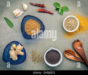 Plusieurs herbes et épices le gingembre, la graine de fenouil, feuilles de sauge, thym séché, l'ail, l'anis étoilé, la poudre de curry, le piment et le fenugrec setup sur panneau de béton. F Banque D'Images