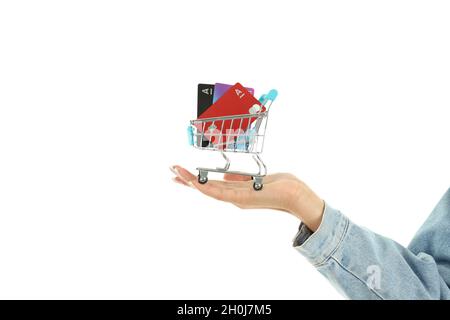 La main femelle tient le chariot de magasin avec des cartes de crédit, isolé sur fond blanc. Banque D'Images