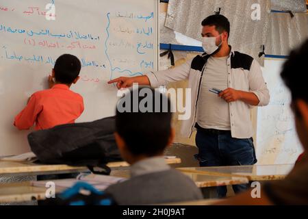 11 octobre 2021, Idlib, gouvernorat d'Idlib, Syrie : Idlib,Syrie.11 octobre 2021.Des enfants de familles syriennes déplacées assistent à des cours dans les 'tentes de petits' des camps de déplacés dans le nord d'Idlib.La nouvelle année universitaire commence dans le gouvernorat d'Idlib au nord-ouest de la Syrie, dans les camps et dans les bâtiments scolaires, avec plus de ressources pour lutter contre la pandémie de Covid-19.En plus des problèmes de sécurité et des obstacles auxquels les enfants syriens doivent toujours faire face depuis le début du conflit dans le pays, l'épidémie de coronavirus de l'an dernier a entravé une plus grande extension de l'accès des enfants à l'éducation (CRED) Banque D'Images