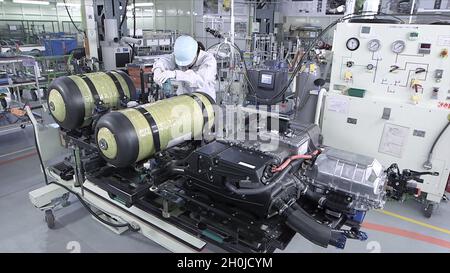 Gros plan d'un travailleur d'usine de voitures à hydrogène qui assemble des piles à combustible à hydrogène. Banque D'Images