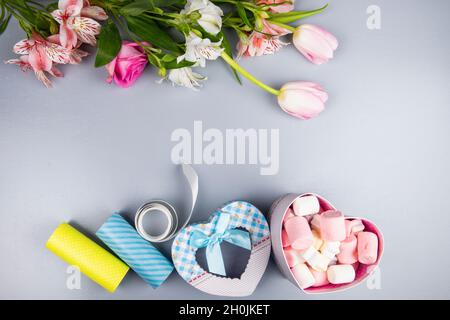 vue de dessus de la tulipe rose et blanc de couleur et fleurs de rose avec alstroemeria et coeur de forme boîte de cadeau rempli de guimauve sur fond blanc Banque D'Images