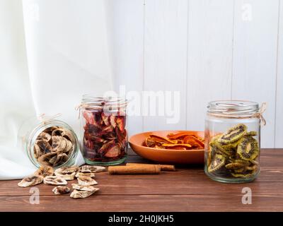 vue latérale de divers fruits en tranches dans des pots de verre de banane kiwi et fraise sur fond de bois Banque D'Images