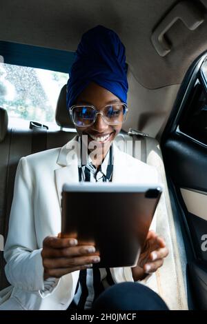 de belles femmes d'affaires qui se rendent à l'aéroport en voiture, en partant pour un voyage de travail.Utilisation d'un smartphone pour créer un appel téléphonique Banque D'Images