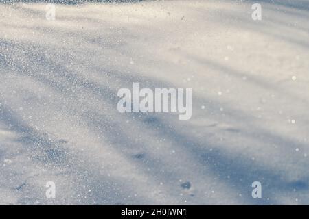 magnifique fond de paysage enneigé, bandes d'ombres et faisceaux lumineux de lumière du soleil. espace pour le texte, surface de paysage d'hiver de saison avec une astuce de lumière, cristaux soufflés de neige dans l'air Banque D'Images