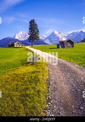 Sentier de campagne à travers les pâturages alpins avec des cabanes en face des monts Karwendel près de Klais, Allemagne, Bavière, Oberbayern, haute-Bavière Banque D'Images