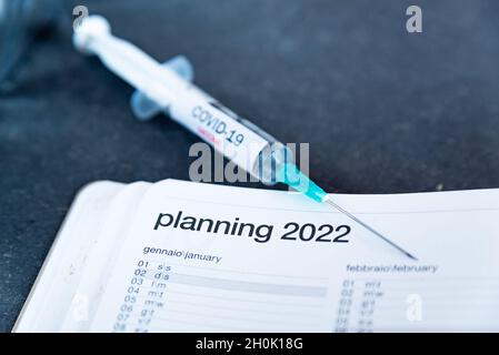 Le vaccin Covid jab et le calendrier 2022, concept de la campagne de vaccination en 2022. Seringue sont considérés sur le calendrier comme un concept pour le 3ème vaccin Covid-19 d Banque D'Images