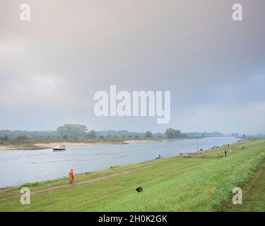 les gens marchent leur chien sur le remblai de la rivière ijssel dans le deventer Banque D'Images