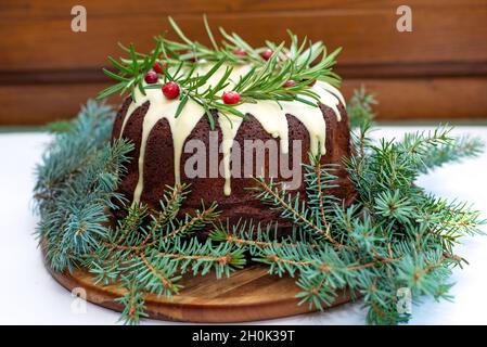 Gâteau de Noël au caramel, décoré de chocolat blanc, de canneberges et de pâtisseries de fête au romarin.Mise au point sélective douce. Banque D'Images