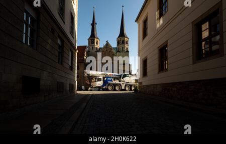 13 octobre 2021, Saxe-Anhalt, Merseburg: Une grue conduit au-dessus de la place de la cathédrale.Auparavant, la grue avait soulevé la nouvelle cloche de Friede dans le beffroi de la cathédrale.Maintenant, dans les prochaines semaines, des travaux de reconstruction doivent avoir lieu afin que la cloche ait assez d'espace dans la tour et puisse sonner pour la première fois le jour de la réforme, le 31 octobre.La cloche de Friede, qui pèse près de 900 kilogrammes, a été récemment moulée pour la cathédrale impériale de Freiberg, en Saxe, pour marquer le 1000e anniversaire de la consécration de la cathédrale de Merseburg.Elle a été consacrée pendant les festivités au début du mois d'octobre. Banque D'Images