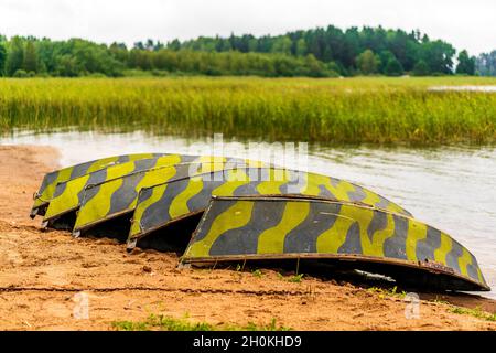 OAR, bateaux rentournés sur la rive d'un lac forestier.Des barques à ciel ouvert près d'un quai sur la rive d'un beau lac, par une journée d'été calme et nuageux. Banque D'Images