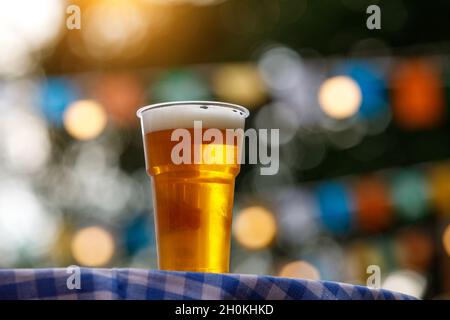 Verre de bière en plastique sur la table avec nappe à carreaux Banque D'Images