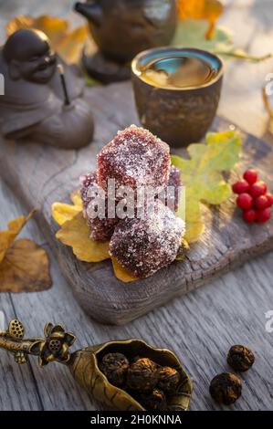 Marmelade de fruits maison.Des cubes rouges de marmelade dans le sucre sont servis avec du thé sur la table.Bonbons faits main. Banque D'Images