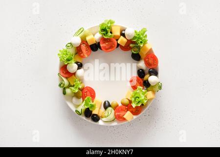 Guirlande de Noël d'en-cas de vacances, canapés, tomates, olives, légumes,fromage mozzarella.Hors-d'œuvre de Noël sur fond blanc.Vue de dessus. Banque D'Images