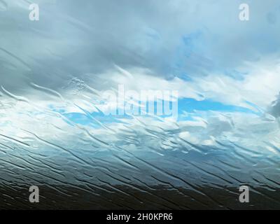 La pluie traverse un pare-brise de voiture sur une plage exposée dans le nord de Norfolk, Angleterre, Royaume-Uni Banque D'Images