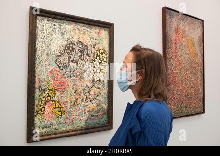 Londres, Royaume-Uni, 13 octobre 2021 : à la foire d'art Frieze Masters de Regent's Park, des œuvres du XXe siècle et toutes les époques précédentes, jusqu'aux artefacts de la Grèce antique et de Rome, sont exposées aux acheteurs potentiels jusqu'au dimanche 17 octobre.Une femme admire une œuvre sans titre de 1944 de Janet Sobel, une artiste américaine autodidacte qui a été très influente sur Jackson Pollock.Anna Watson/Alay Live News Banque D'Images