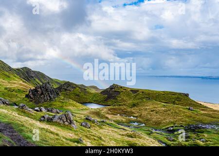 Vue depuis le vieil homme de Storr avec des nuages bas et un arc-en-ciel sur le détroit de Raasay, île de Skye, Écosse Banque D'Images