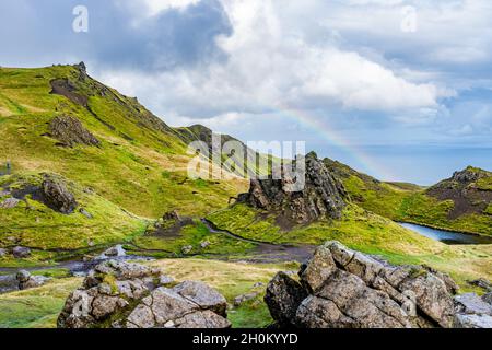 Vue depuis le vieil homme de Storr avec des nuages bas et un arc-en-ciel sur le détroit de Raasay, île de Skye, Écosse Banque D'Images