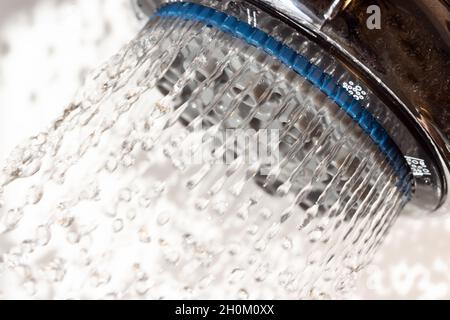 L'eau coule de la pomme de douche, vue rapprochée. Banque D'Images