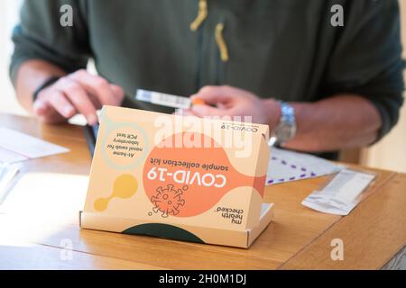 Test PCR - Homme utilisant COVID-19 à domicile Kit de test par écouvillon PCR - Royaume-Uni Banque D'Images