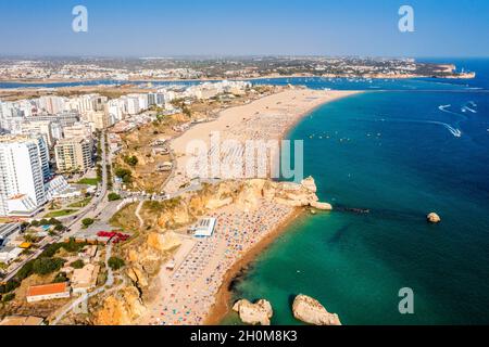 Vue aérienne de Portimao touristique avec une large plage de sable de Rocha pleine de gens, Algarve, Portugal Banque D'Images