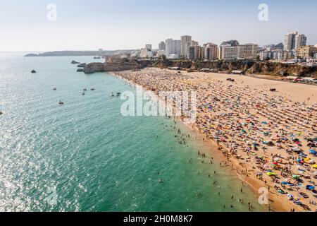 Vue aérienne de Portimao touristique avec une large plage de sable de Rocha pleine de gens, Algarve, Portugal Banque D'Images