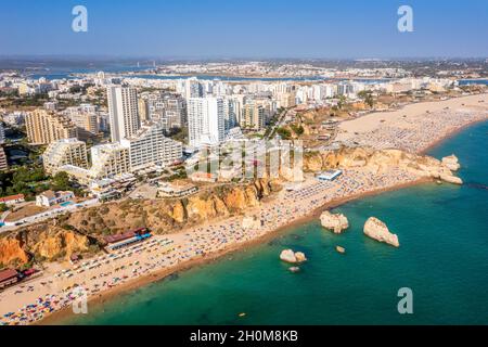 Vue aérienne de Portimao touristique avec une large plage de sable de Rocha pleine de gens, Algarve, Portugal Banque D'Images