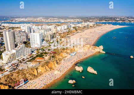 Vue aérienne de Portimao touristique avec une large plage de sable de Rocha pleine de gens, Algarve, Portugal Banque D'Images