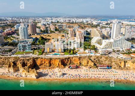 Vue aérienne de Portimao touristique avec une large plage de sable de Rocha pleine de gens, Algarve, Portugal Banque D'Images