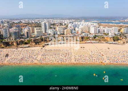 Vue aérienne de Portimao touristique avec une large plage de sable de Rocha pleine de gens, Algarve, Portugal Banque D'Images