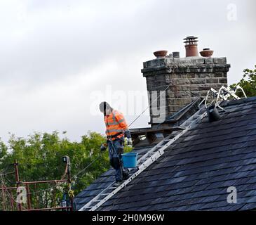 Un ouvrier travaillant sur un toit de maison Banque D'Images